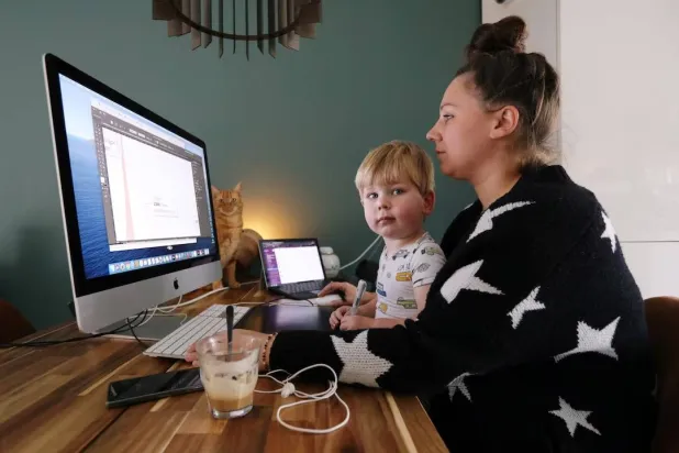 سيدة تعمل في منزلها وأمامها طفلها في هولندا (أرشيفية - رويترز)