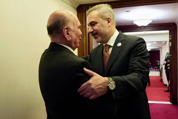 وزير الخارجية العراقي فؤاد حسين خلال مصافحة وزير الخارجية التركي هاكان فيدان على هامش منتدى الدوحة (الصفحة الرسمية لوزارة الخارجية العراقية بـ«فيسبوك»)