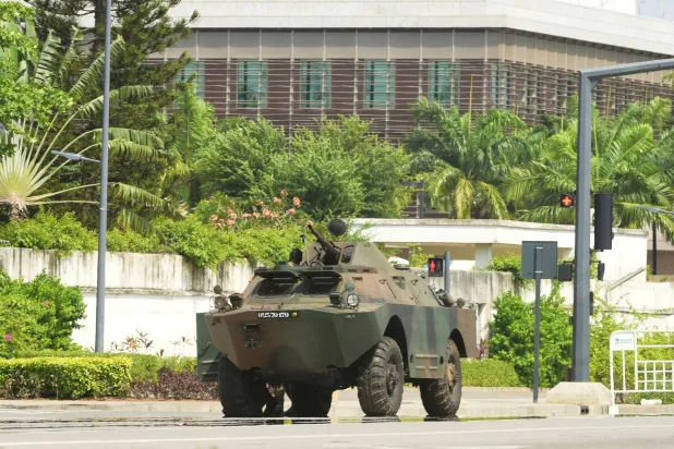 انتشار عسكري خارج مقر الإذاعة والتلفزيون في كوتونو 7 ديسمبر (رويترز)