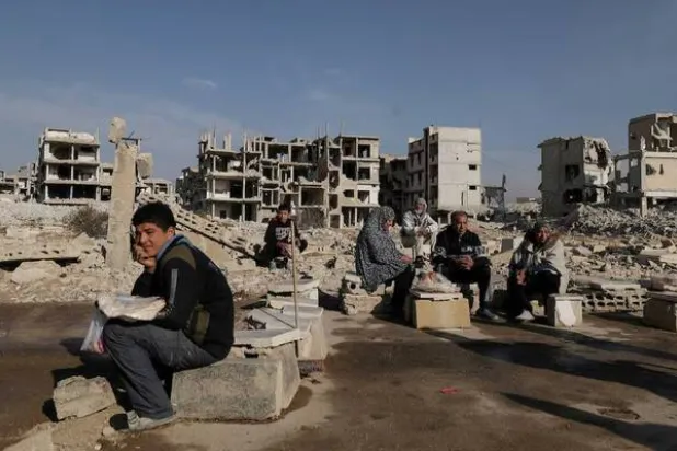 People sit after receiving bread from Ecir Kapici, Turkish humanitarian NGO at Al-Yarmouk Palestinian refugee camp, after Syria's Bashar Al-Assad was ousted, in Damascus, Syria, December 20 , 2024. (Reuters)
