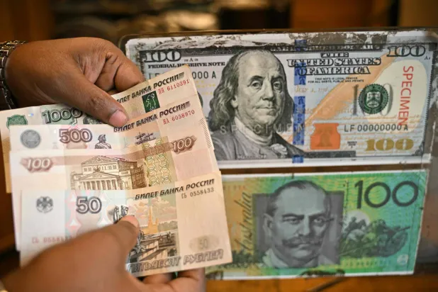موظف يَعدّ أوراقاً نقدية من الروبل الروسي بمتجر لصرف العملات الأجنبية في بنغالورو (أ.ف.ب)