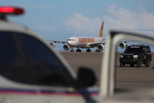 طائرة تحمل مهاجرين فنزويليين عائدين من المكسيك تهبط في مطار سيمون بوليفار الدولي في مايكيتيا بفنزويلا (إ.ب.أ)