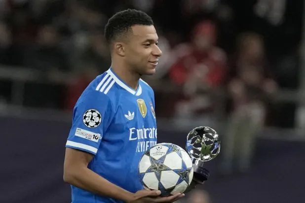 Real Madrid's Kylian Mbappe poses with the trophy after scoring four goal during the Champions League opening phase soccer match between Olympiacos and Real Madrid, in in Piraeus port, near Athens, Greece, Wednesday, Nov. 26, 2025. (AP Photo/Petros Giannakouris)