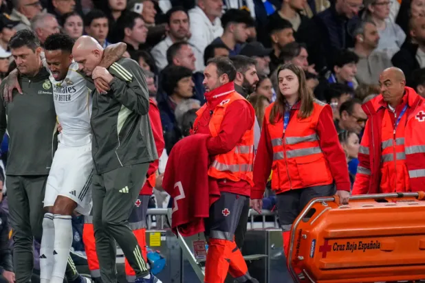 Real Madrid's Eder Militao is assisted from the pitch after getting an injury during the Spanish La Liga soccer match between Real Madrid and Celta Vigo in Madrid, Spain, Sunday, Dec. 7, 2025. (AP Photo/Manu Fernandez)