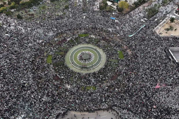 سوريون يحتشدون في ساحة الأمويين بدمشق بمناسبة ذكرى سقوط نظام بشار الأسد أمس (أ.ب) ... وفي الإطار الرئيس الشرع يحيّي الحشد  (أ.ب) 