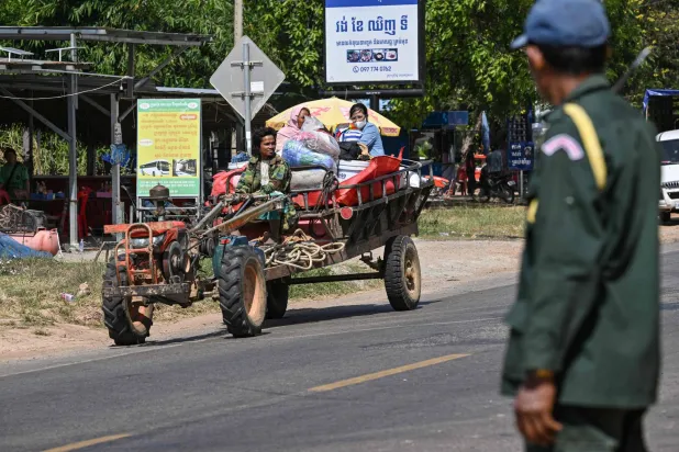 شرطي يقف بينما يتم إجلاء السكان إثر اشتباكات على طول الحدود الكمبودية التايلاندية في مقاطعة سيام ريب (أ.ف.ب)