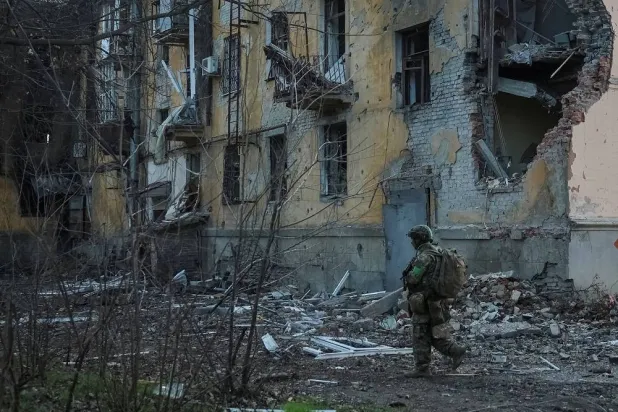 A serviceman of the 49th Separate Assault Battalion Carpathian Sich of the Armed Forces of Ukraine walks near an apartment building damaged by Russian military strike, amid Russia's attack on Ukraine, in the frontline town of Kostiantynivka in Donetsk region, Ukraine December 7, 2025. (Reuters)