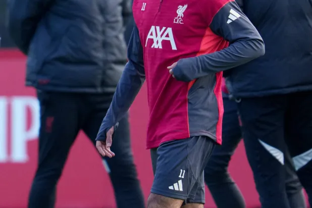 Liverpool's Mohamed Salah passes manager Arne Slot, left, as he takes part in a training session in Liverpool, England, Monday, Dec. 8, 2025. (AP Photo/Jon Super)