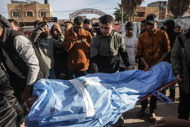 أصدقاء وأقارب للفلسطيني الراحل محمد الجرو يحملون جثمانه خلال جنازته داخل دير البلح يوم 9 ديسمبر 2025 بعد استشهاده في غارة جوية إسرائيلية (أ.ف.ب)