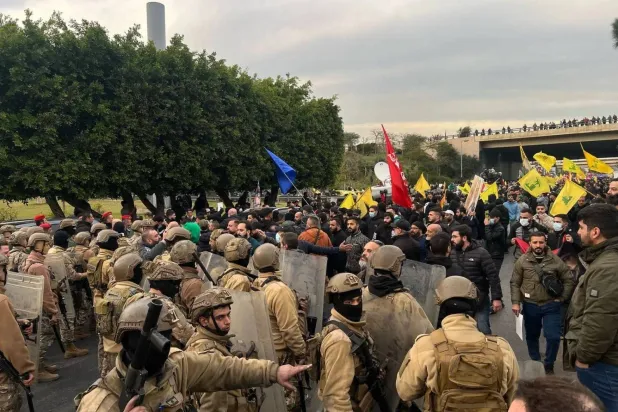 عناصر من الجيش اللبناني يواجهون معتصمين يرفعون أعلام «حزب الله» على طريق المطار حيث نفذوا في فبراير الماضي تحركات رفضاً لقرار لبنان عدم استقبال طائرة إيرانية (الشرق الأوسط)