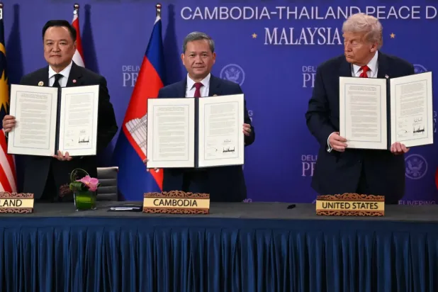 ABD Başkanı Donald Trump (sağda), 26 Ekim 2025'te Kuala Lumpur'da düzenlenen 47. ASEAN Zirvesi'nin oturum aralarında ateşkes anlaşmasının imza töreninde Kamboçya Başbakanı Hun Manh (ortada) ve Tayland Başbakanı Anutin Charnvirakul'a bakıyor (AFP)