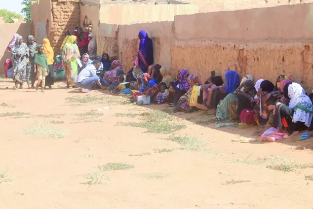 Geçtiğimiz kasım ayında Kuzey Kordofan'dan gelen yerinden edilmiş kişiler, Omdurman şehrinde bir duvarın gölgesinde oturuyor. (AFP)