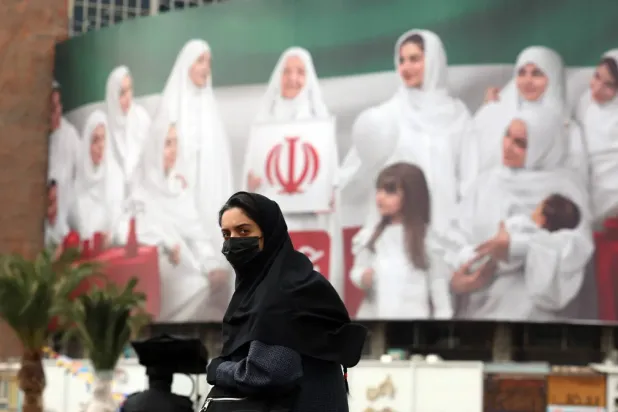 Bugün Tahran'daki Valiasr Meydanı'nda İran bayrağı şeklinde dev bir reklam panosunun önünden geçen bir kadın (EPA)