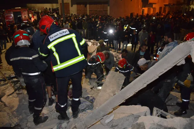 عناصر شرطة وإسعاف ورجال إنقاذ في موقع الحادثة للبحث عن ناجين تحت الأنقاض (إ.ب.أ)