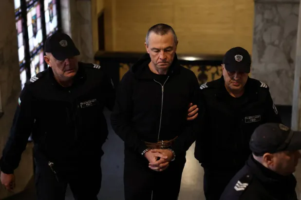 عنصران من الشرطة البلغارية يقودان الروسي إيغور غريتشوشكين إلى قاعة المحكمة في بلغاريا للاستماع إلى إفادته (رويترز)