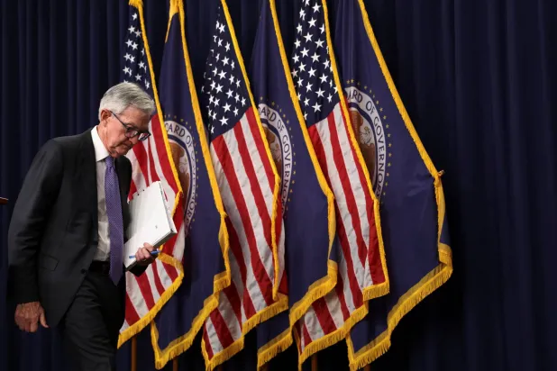 باول مغادراً القاعة بعد انتهاء مؤتمره الصحافي عقب قرار خفض الفائدة (رويترز)