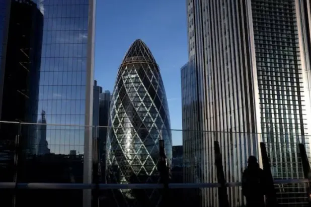 شخص ينظر من حديقة على سطح مبنى في الحي المالي لمدينة لندن (رويترز)