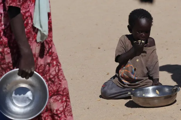 An orphaned Sudanese child eats at a refugee camp in eastern Chad, November 22, 2025 (Reuters).