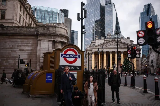 People exit the London Underground station at Bank, outside the Bank of England (L) and the Royal Exchange building (back R) in central London on December 12, 2025. (Photo by HENRY NICHOLLS / AFP)