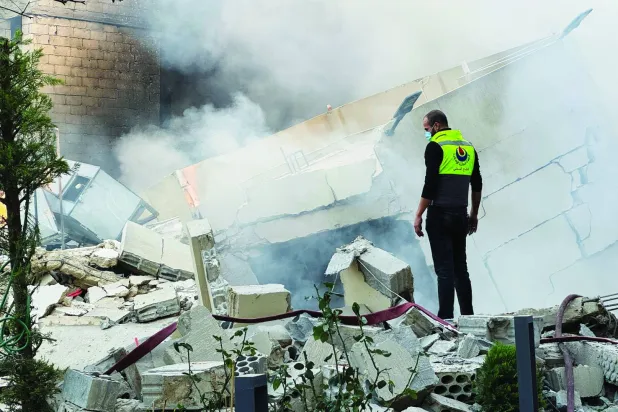 عنصر في «الدفاع المدني» يقف على ركام منزل استهدفته غارة إسرائيلية ببلدة جباع بجنوب لبنان (رويترز)