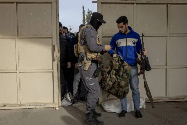 جانب من عملية تسليم جنود النظام السابق أسلحتهم لقوات الحكومة الجديدة في اللاذقية يوم 16 ديسمبر 2024 (نيويورك تايمز)