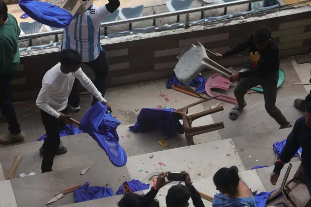 Fans throw bottles and chairs, vandalizing hoardings at Salt Lake Stadium in Kolkata, West Bengal, India, 13 December 2025. Following Messi's brief five-minute appearance, unrest broke out among fans who had paid a significant amount but were unable to see the Argentine football legend.  EPA/PIYAL ADHIKARY