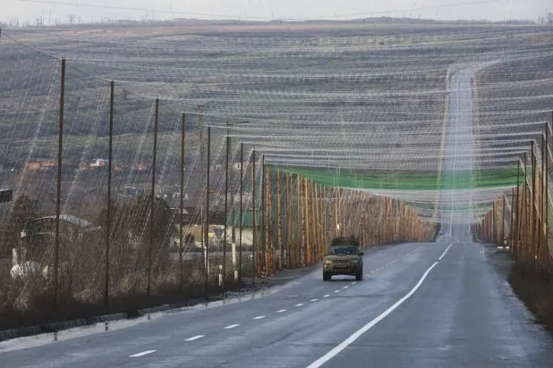 Anti-drone nets hang taut along a road near the city of Izyum of Kharkiv region, northeastern Ukraine, 12 December 2025. (EPA)