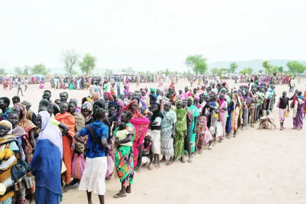 Kuzey Kordofan'daki bir kampta gıda yardımı için sıra bekleyen yerinden edilmiş kişiler (AFP)