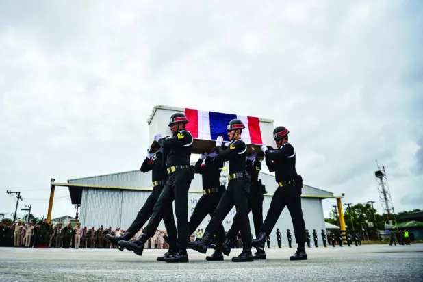 TOPSHOT - Soldiers carry the coffin of Special Forces volunteer Mustakim Majehma, who died amid clashes along Cambodia-Thailand border, during a military ceremony at Narathiwat airport in Thailand's southern province of Narathiwat on December 14, 2025. (Photo by Madaree TOHLALA / AFP)