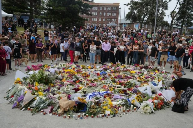 People gather around a tribute for shooting victims outside the Bondi Pavilion at Sydney's Bondi Beach, Monday, Dec. 15, 2025, a day after a shooting. (AP)