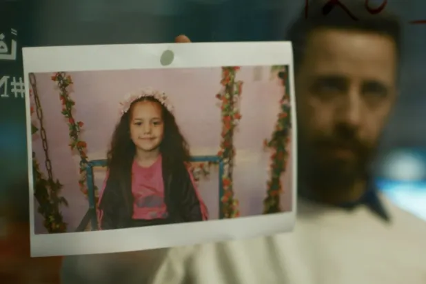 الممثل معتز ملحيس وأمامه صورة الطفلة هند رجب في مشهد من الفيلم (أ.م.د.ب)