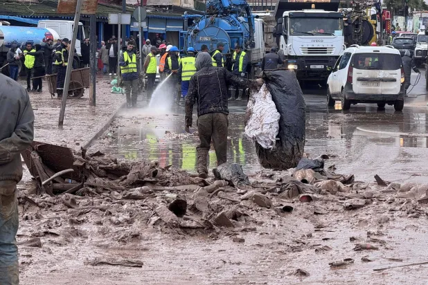 عمال البلدية يرفعون الركام من أحد شوارع بلدة آسفي الساحلية الاثنين (أ.ف.ب)