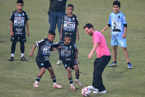 ليونيل ميسي يلعب الكرة مع أطفال في نيودلهي (أ.ف.ب)
