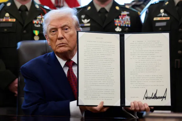 الرئيس الأميركي خلال توقيعه الأمر التنفيذي في البيت الابيض (رويترز)