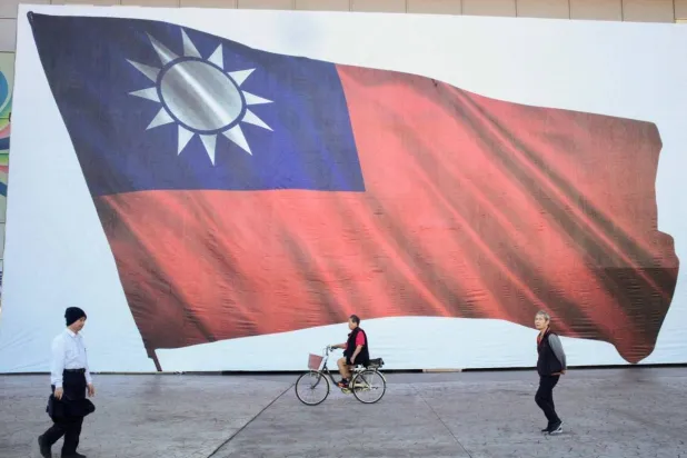 People walk past a Taiwanese flag in New Taipei City. (AFP/Jiji Press)