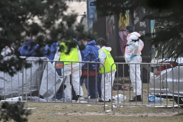 Adli tıp uzmanları, Sidney'deki Bondi Plajı'nda meydana gelen silahlı saldırı olay yerinde kurbanlardan birinin cesedini inceliyor (EPA)