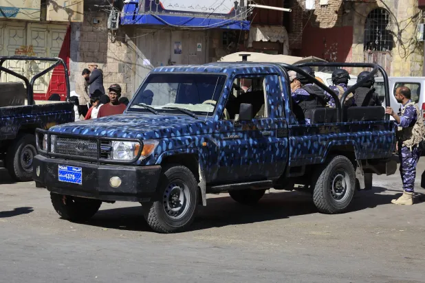 مسلحون حوثيون على متن عربة أمنية في أحد شوارع العاصمة اليمنية المختطفة صنعاء (إ.ب.أ)