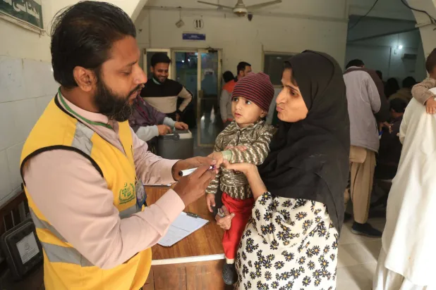 A health worker marks a child’s finger after administering a polio vaccination in Hyderabad, Pakistan, 15 December 2025. EPA/NADEEM KHAWAR 