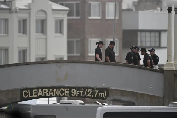 Adli tıp uzmanları, Sydney'deki Bondi Plajı'nda silahlı saldırganların ateş açtığı köprüde duruyor (EPA)