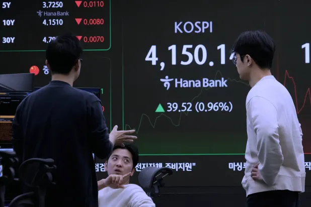 متعاملون بالعملات يتابعون مؤشر «كوسبي» في غرفة تداول بنك «هانا» بسيول (أ.ب)