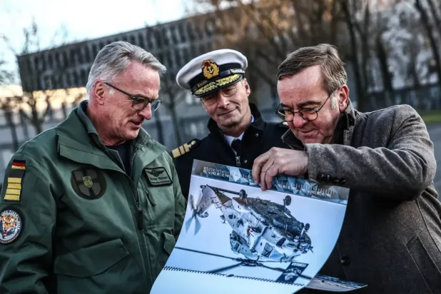 Almanya Savunma Bakanı Boris Pistorius (sağda), Alman Donanma Komutanı Koramiral Jan Christian Kac (ortada) ve Kaptan Bruder Nielsen, Berlin'deki Savunma Bakanlığı'nda düzenlenen bir Sea Tiger helikopterinin teslim töreninde askeri belgeleri inceliyor... 16 Aralık 2025 (EPA)