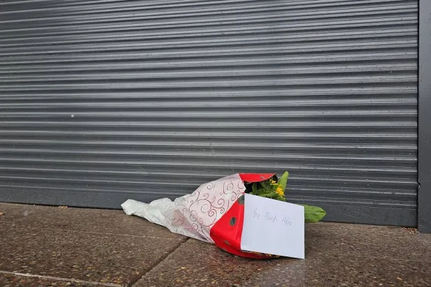 Flowers with a note that read "The Bondi Hero" are left outside tobacco shop owned by Ahmed al-Ahmed, the bystander who is hailed as the "Bondi hero" after he charged at one of the gunmen and seized his rifle during the deadly shooting at Bondi Beach, in Sydney, Australia, December 16, 2025. (Reuters)