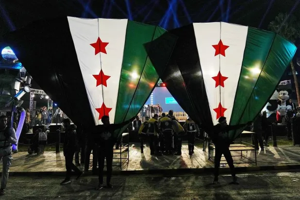 Syrian citizens wave their national flags during celebrations marking the first anniversary of the ousting of former President Bashar al-Assad in Damascus, Syria, Monday, Dec. 8, 2025. (AP)