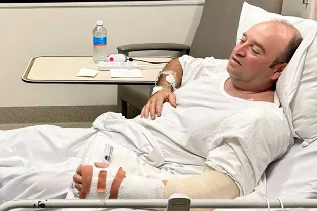 أحمد الأحمد الرجل الذي تصدّى لأحد مهاجمي شاطئ بونداي ونزع سلاحه وهو يتحدث إلى رئيس وزراء ولاية نيو ساوث ويلز كريس مينز (أ.ف.ب)