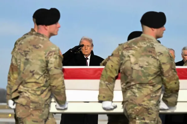 ABD Başkanı Donald Trump, Suriye'deki bir saldırıda öldürülen iki Ulusal Muhafız’ın naaşlarının ülkeye getirilmesi töreninde selam veriyor (AFP)