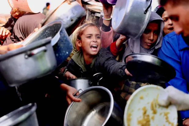  فلسطينيون يتزاحمون للحصول على حصص غذاء في خان يونس بجنوب قطاع غزة أمس (أ.ف.ب)