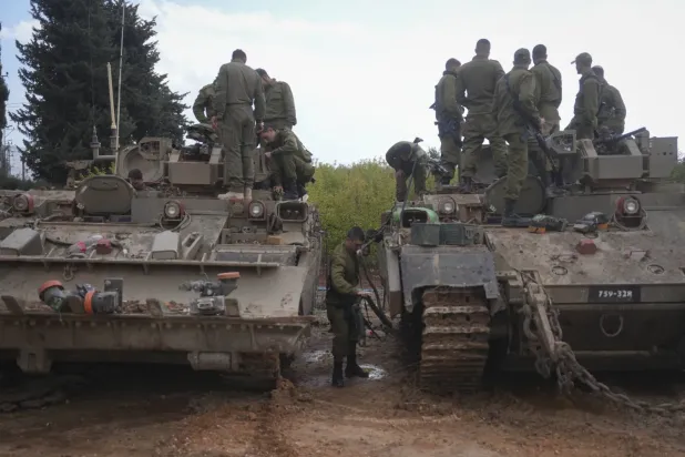 Yukarı Celile'deki Lübnan sınırına yakın Avivim tarım yerleşiminin dışında zırhlı askeri araçların üzerinde oturan İsrail askerleri, 28 Kasım 2024 (AP)