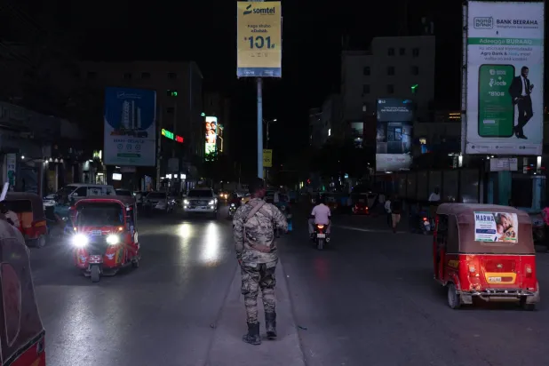 ضابط شرطة صومالي يقوم بدورية في شارع مزدحم ليلاً بمقديشو 10 نوفمبر 2025 (أ.ف.ب)