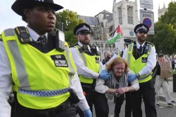 Police officers carry a protester during a protest to support Palestine Action in London, Saturday, Sept. 6, 2025. (AP Photo/ Joanna Chan) 