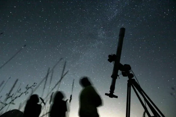 People look up to the sky from an observatory near the village of Avren, Bulgaria, Aug. 12, 2009. (AP Photo/Petar Petrov, File)


